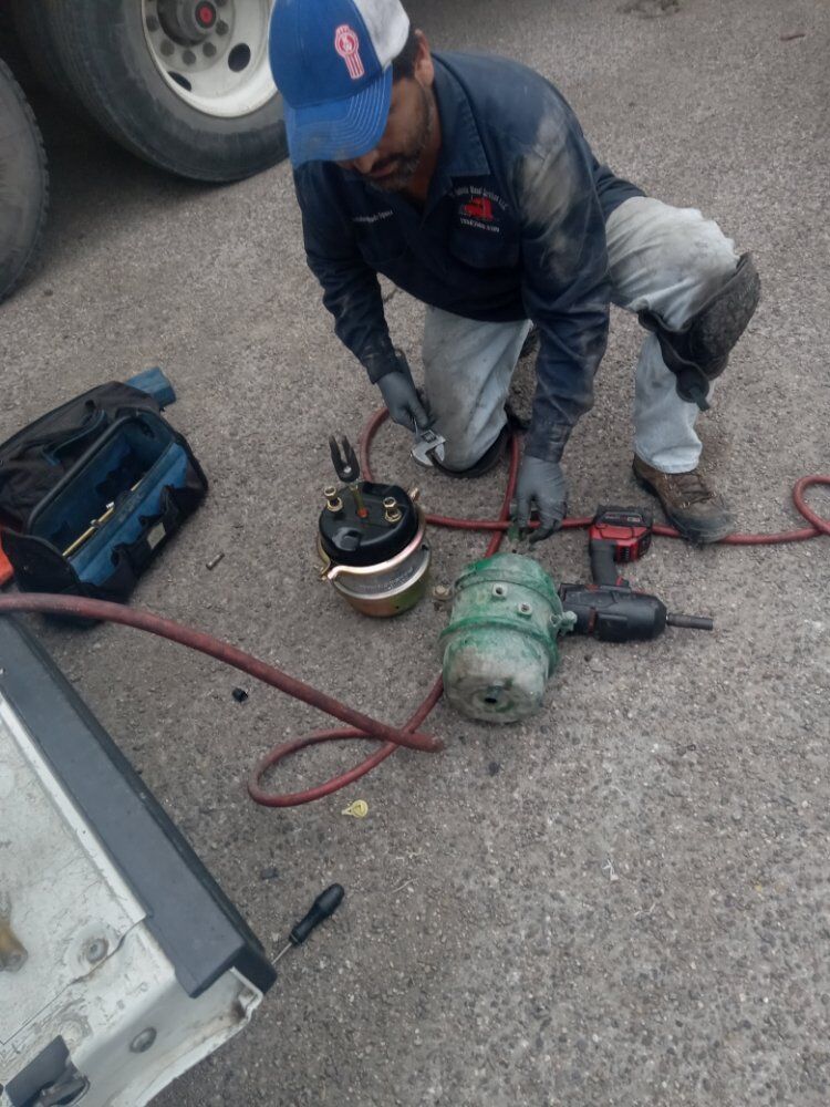 Technician using air tools on a wheel during a roadside brake job