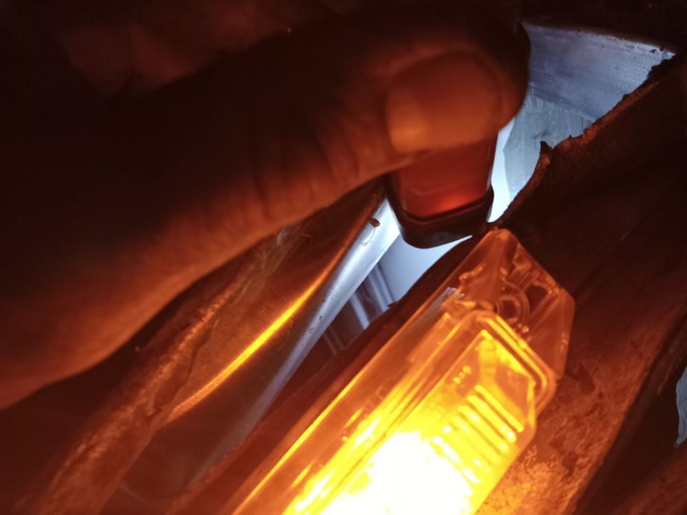 Amber marker light glowing during a night trailer lighting repair