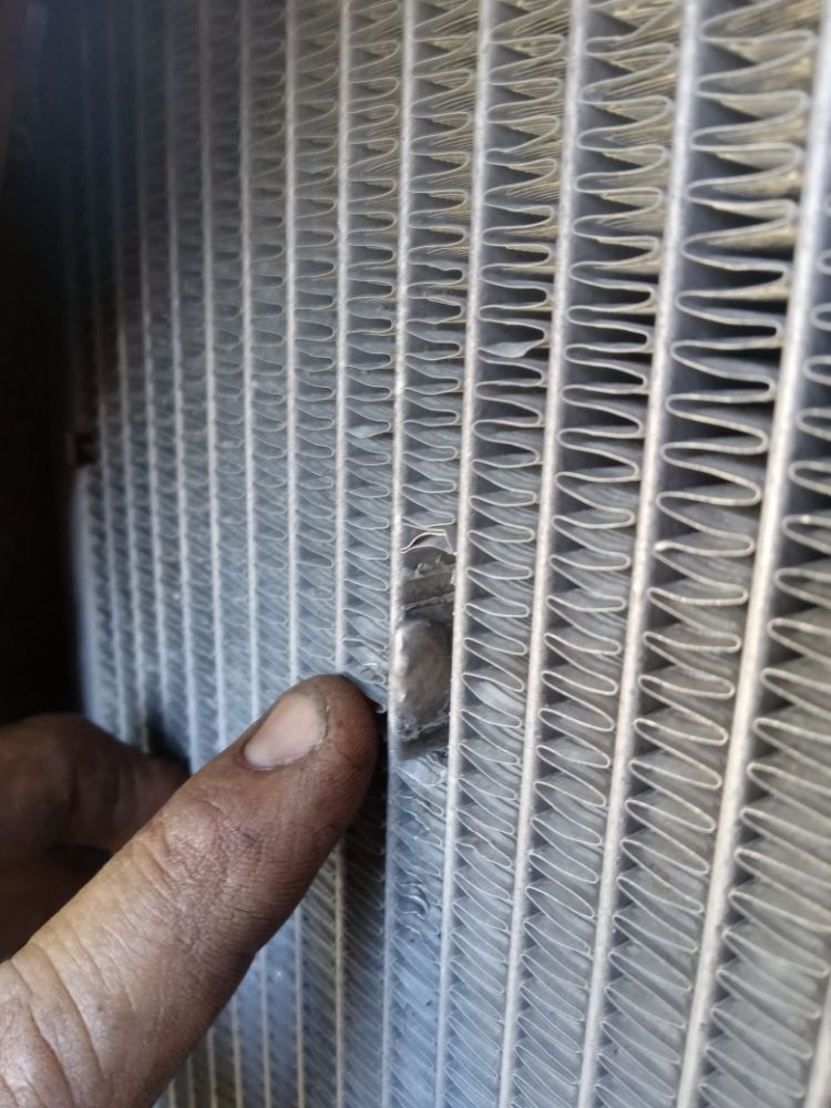 Radiator core inspected for damage during a cooling system diagnosis