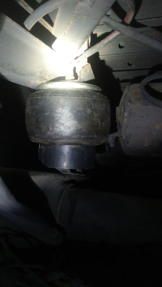 Air spring and suspension components inspected under a trailer at night